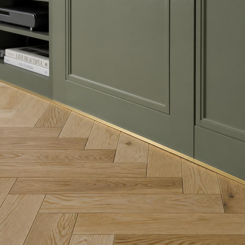 Detail of herringbone oak floor meeting panelled cabinetry