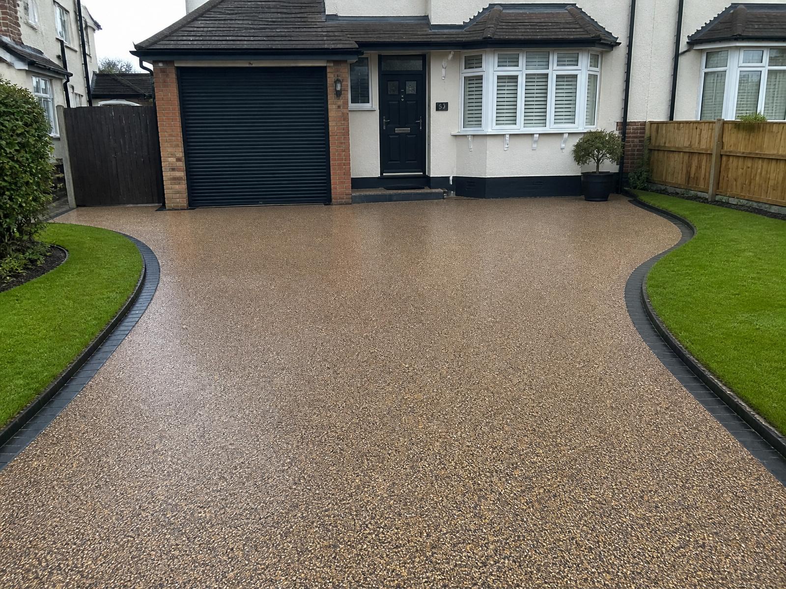 The same suburban driveway resurfaced with warm honey resin-bound gravel and clean charcoal edging